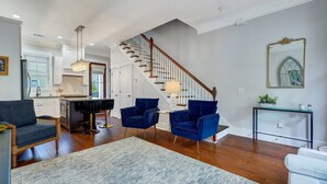 Un área de estar amplia con una escalera, una cocina y un comedor.