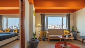 A modern living room with a sofa, a coffee table, and two potted plants. - The Hosteller Bangalore, Marathahalli (Bengaluru)