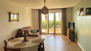 A dining area with a round table, chairs, and a hanging light fixture. - Large studio with sea view - Terrace & private parking (Saint-Cyr-sur-Mer)