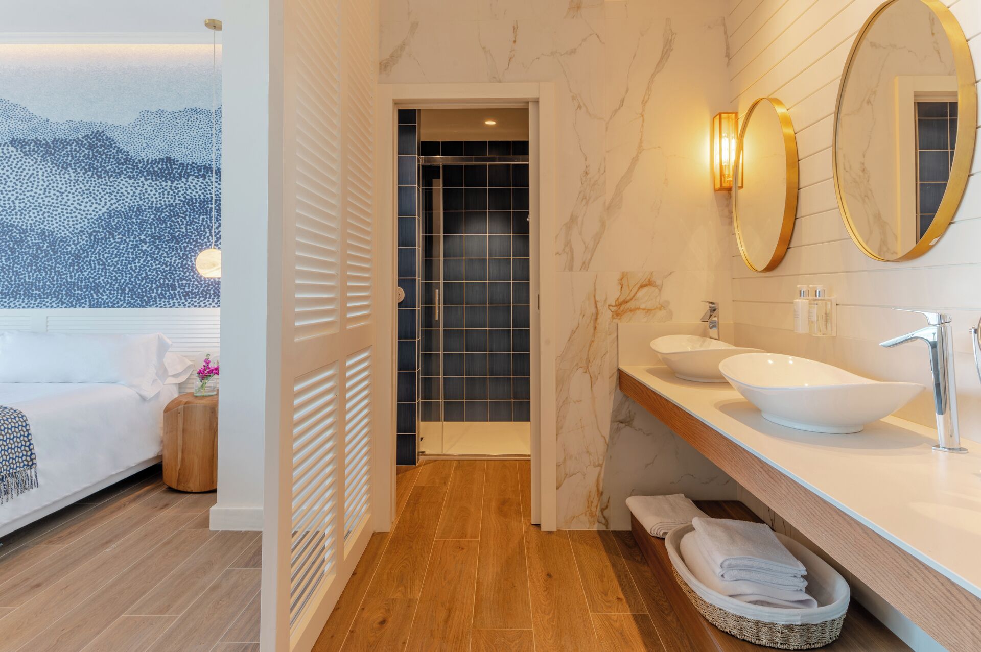 Un baño moderno con dos lavamanos, un espejo grande y una ducha a ras de suelo.