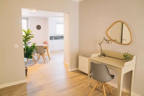 Un interior moderno con un escritorio, una silla y un espejo redondo en la pared.