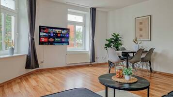 Relax in this stylish living room with a flat-screen TV, comfortable sofa, and dining area.