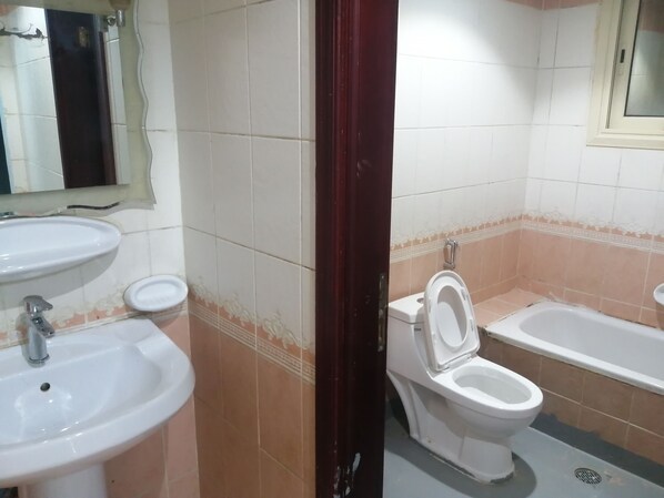 A bathroom with two sinks, a toilet, and a bathtub. - Caesar Star (Al Quwaiiyah)