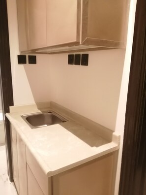 A small kitchen with a sink, cabinets, and a countertop. - Caesar Star (Al Quwaiiyah)