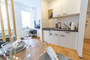 A modern kitchen with white cabinets, a black countertop, and a small island with a sink.
