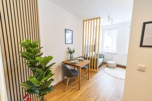 A dining area with a wooden table, chairs, and a potted plant.