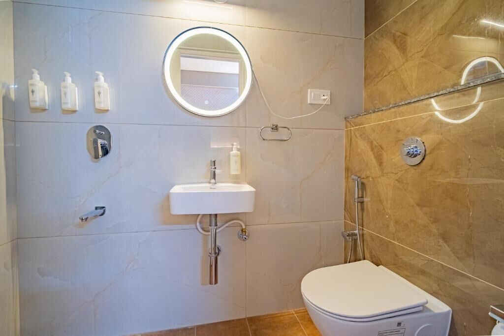 A modern bathroom with a toilet, sink, and shower.
