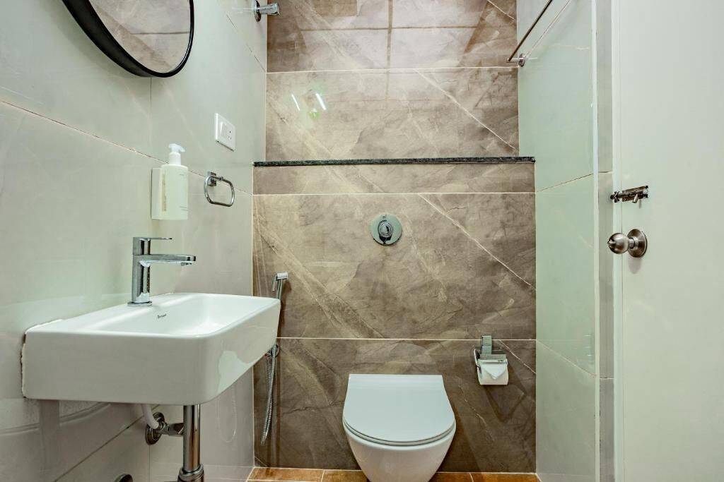 A bathroom with a white sink, a toilet, and a shower area.