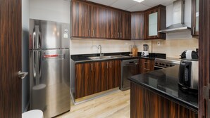 A modern kitchen with wooden cabinets, stainless steel appliances, and a black countertop. - Trendy JBR 2BR w Pool and Gym Marina Views (Dubai)