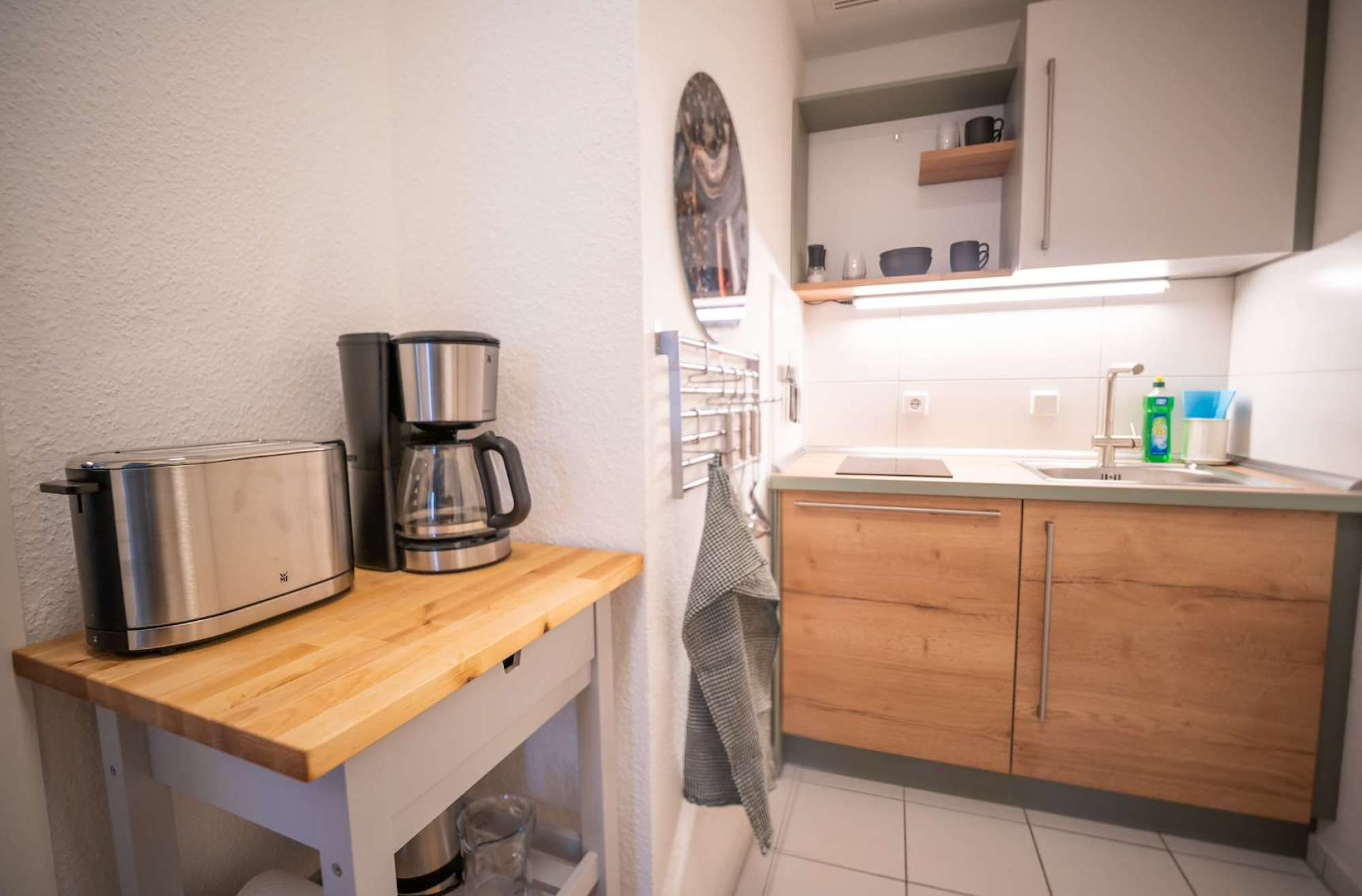 A compact kitchenette with a coffee maker, a toaster, and a sink.