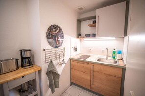 A compact kitchen with a coffee maker, a hanging utensil rack, a sink, and a countertop with a dish soap bottle. - RR | Cozy Apartment | Parking | Kitchen | WIFI (Magdeburg)