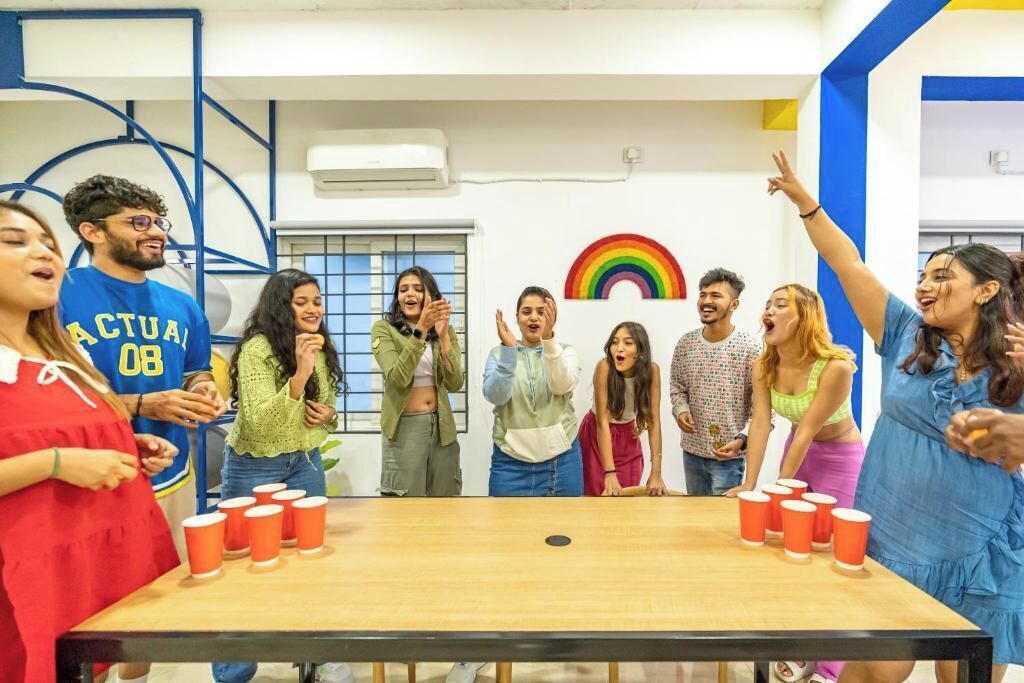 A group of people standing around a table with red cups, possibly playing a game.
