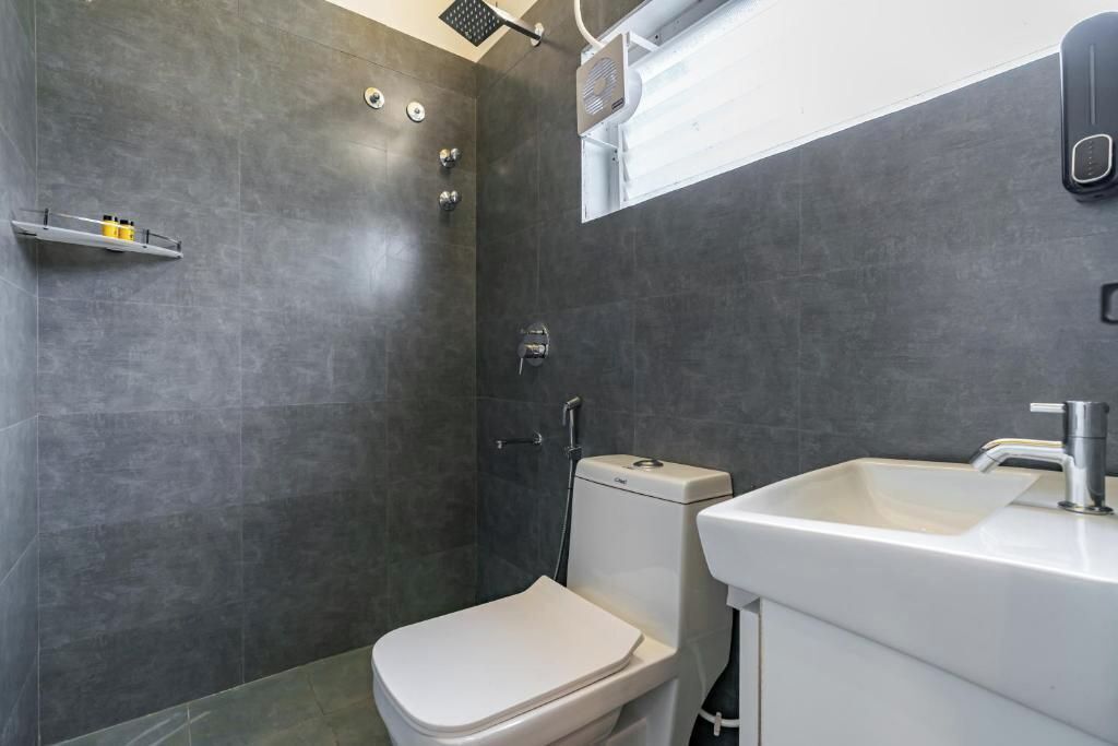 A modern bathroom with a shower, toilet, and sink.