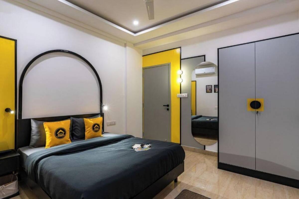 Une chambre à coucher moderne avec un lit, une armoire et un miroir.