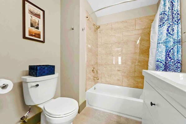 Ein Badezimmer mit Toilette, Badewanne und Duschbereich.