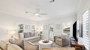 A spacious living room with a sofa set, a coffee table, and a ceiling fan. - Community Pools | LSV | Close to Beach (Santa Rosa Beach)