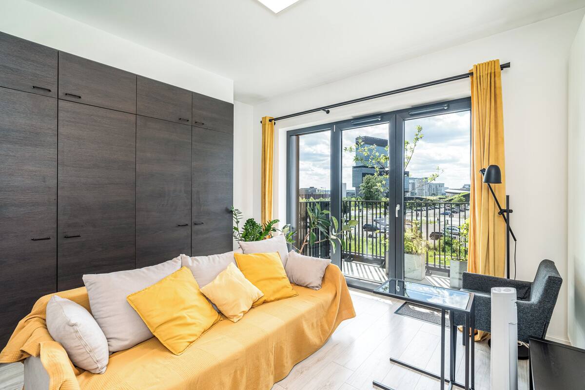 Una sala de estar moderna con un sofá, una mesa y vistas a un balcón.