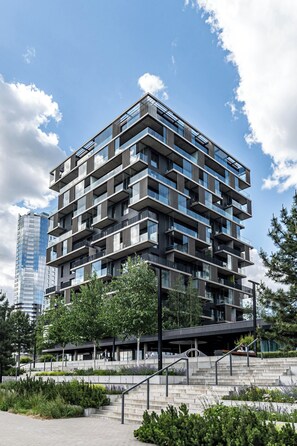 A multi-story building with balconies, a staircase, and a surrounding landscaped area. - RentPlanet - Apartament Góreckiego (Katowice)