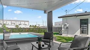 A modern outdoor patio with a pool, seating, and a view of the cityscape. - Modern 5BR Dream • Courts, Playground • Pool_BBQ (Miami)