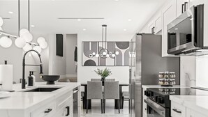 A modern kitchen with white cabinetry, a central island, a dining area with grey chairs, and a pendant light with spherical bulbs. - Modern 5BR Dream • Courts, Playground • Pool_BBQ (Miami)