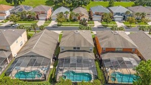 Un quartier résidentiel avec des maisons, une piscine et des panneaux solaires.