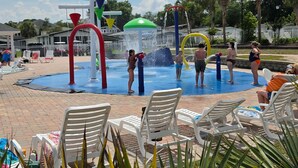 A water park with a water play area, lounge chairs, and a pool. - Coastal Camelot - Walk To Surfside Beach 2 Bedroom Duplex (Murrells Inlet)