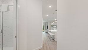 Une salle de bain moderne avec une douche à parois de verre et un pare-baignoire en marbre blanc.