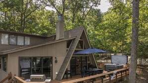 A cabin with a deck, outdoor seating, and a hot tub. - Whitetail Creek Retreat by Innsbrook Vacations! (Innsbrook)