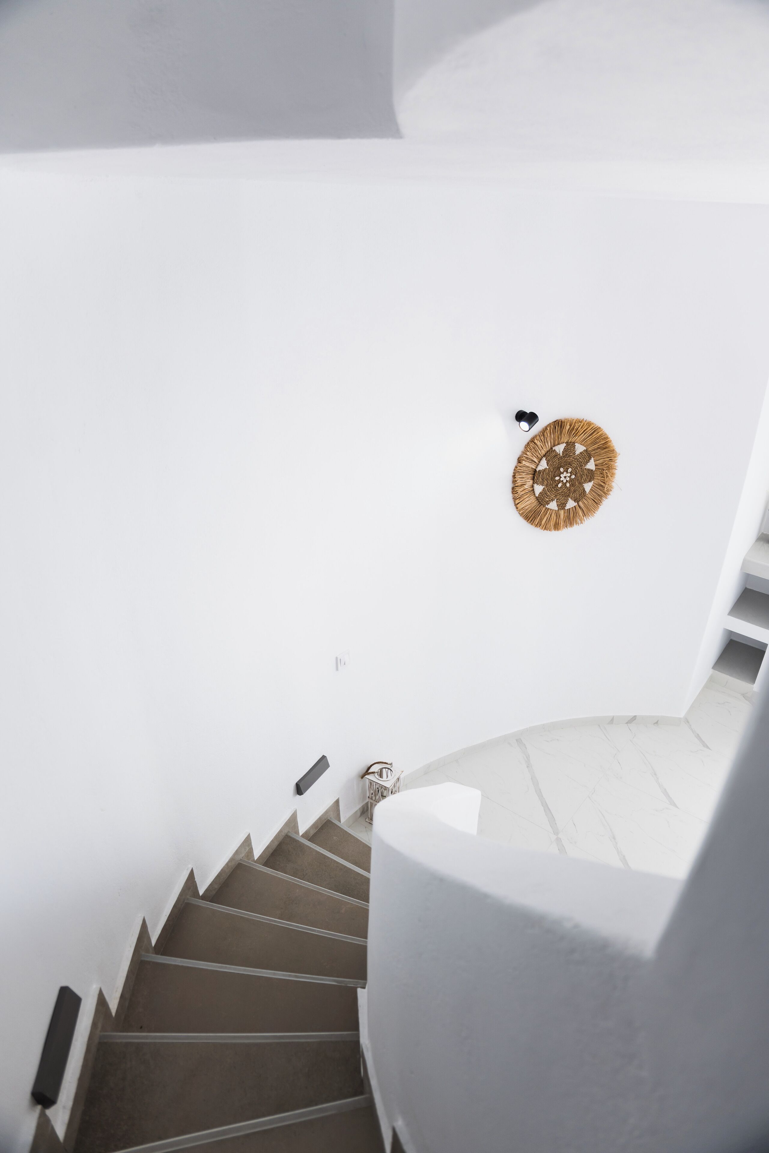 Eine Treppe mit einer weißen Wand und einem dekorativen Wandbehang.