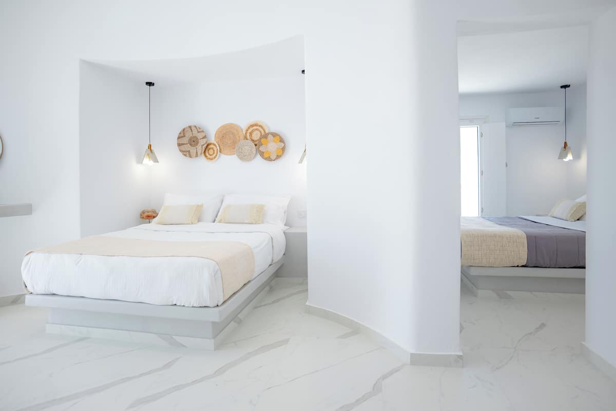 Un dormitorio moderno con cama, mesitas de noche y decoración en la pared.
