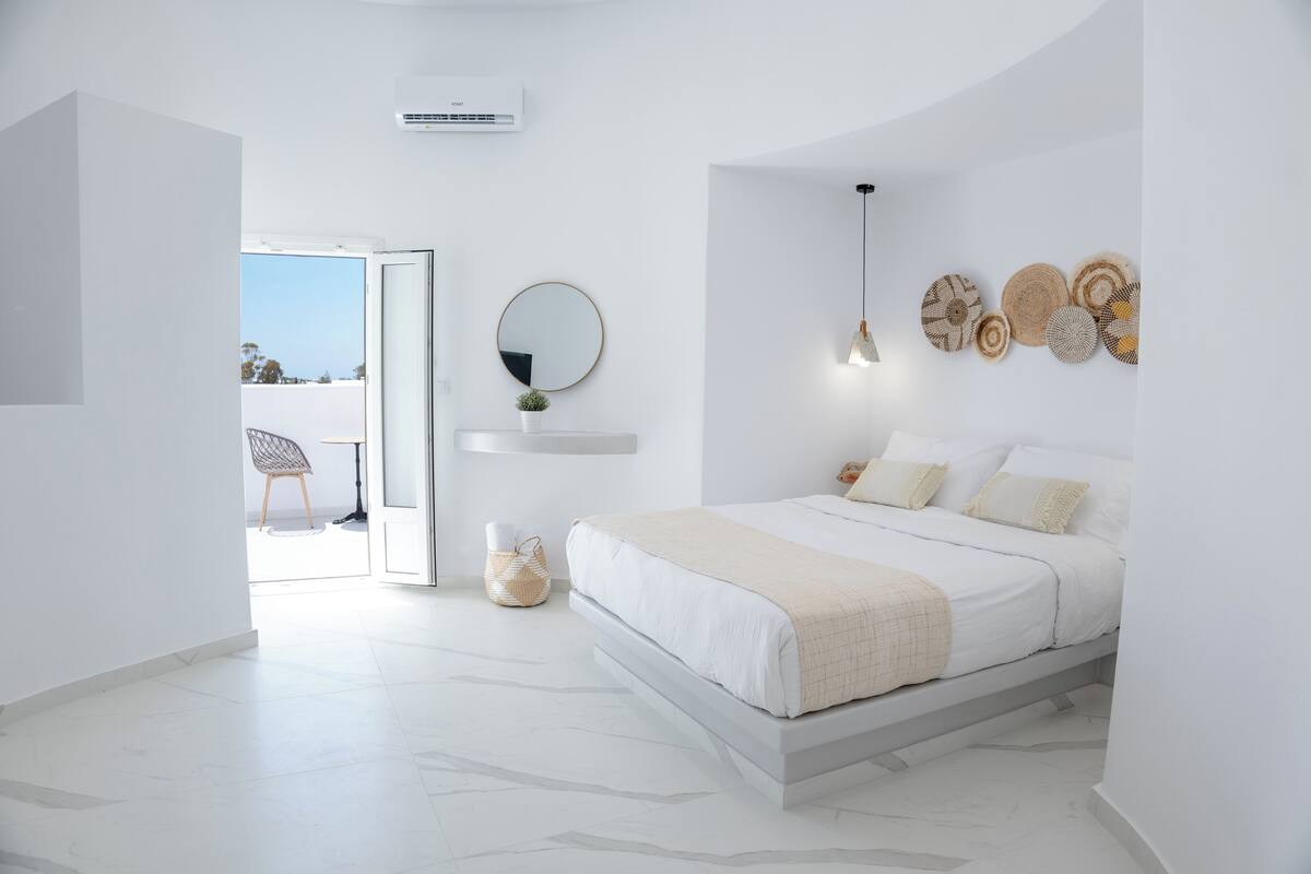 Un dormitorio moderno con cama, un espejo redondo y decoración en la pared.