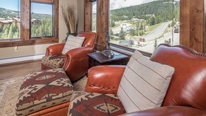 Una habitación acogedora con sofás de cuero y vistas a un paisaje montañoso.