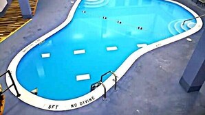 Une piscine avec un panneau indiquant « Il est interdit de plonger » et une étiquette « Il est interdit de plonger » placée sur le bord.