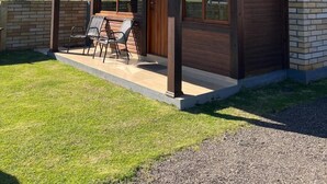 Una casa moderna con un porche cubierto, ventanas amplias y una chimenea de ladrillo.