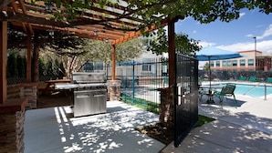 An outdoor patio with a grill, a pool, and a covered seating area. - Studio Near Denver Tech Center | Free Weekday Shuttle + Breakfast! (Centennial)
