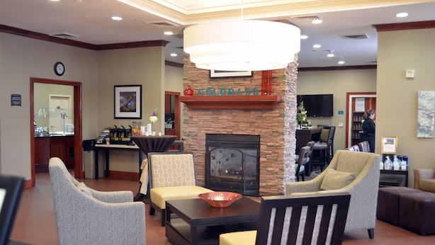 A lobby with a fireplace, seating area, and a reception desk. - Studio Near Denver Tech Center | Free Weekday Shuttle + Breakfast! (Centennial)
