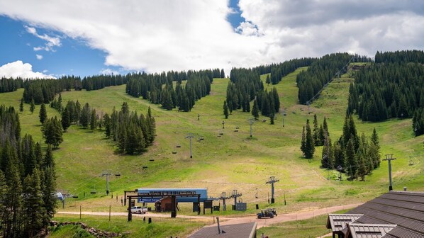 Ein Skigebiet auf dem Berggipfel mit einer Liftstation, Sesselliften und einem Gebäude mit der Aufschrift 'Mountain Top Express'.