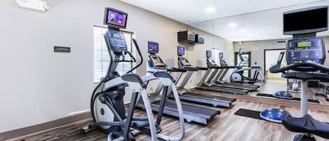 A gym with treadmills, elliptical machines, and stationary bikes.