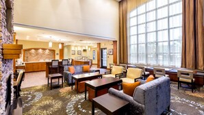 A spacious lobby with comfortable seating, a bar area, and large windows providing natural light. - Short Drive to Texas A&M | Outdoor Pool + Business Center + Fitness Center (College Station)
