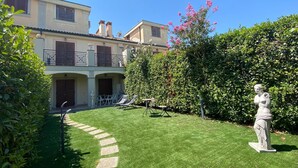 Un jardin bien entretenu, agrémenté d’une statue, d’une piscine et d’un bâtiment doté de balcons.