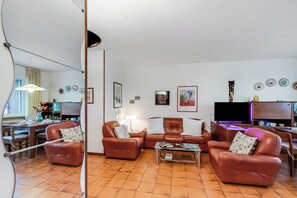 Ein Wohnzimmer mit braunen Ledersitzmöbeln, einem Couchtisch und einem Fernseher.