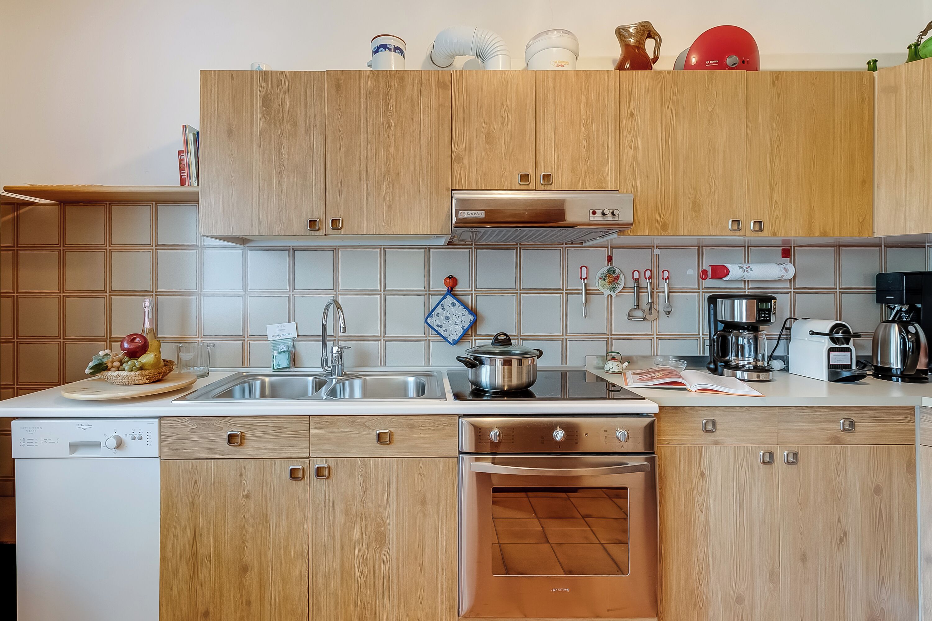 A modern kitchen with wooden cabinets, stainless steel appliances, and a built-in oven.