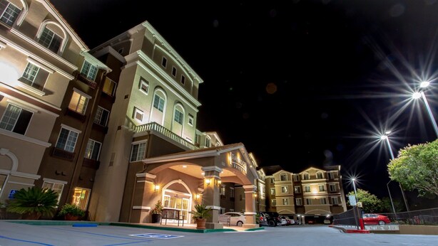 A hotel with a large entrance, multiple floors, and a parking area. - Air-Conditioned Studio near Downtown San Jose | FREE Shuttle (Milpitas)