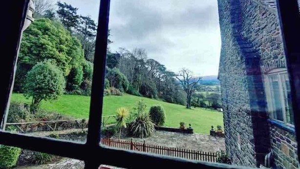 A view from a window of a stone building with a green landscape and trees. - bossington bunkhouse (Bossington)