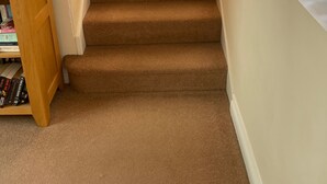 A carpeted staircase with a wooden handrail leading to a door. - Seaside Retreat in Exmouth With Stunning Views (Exmouth)