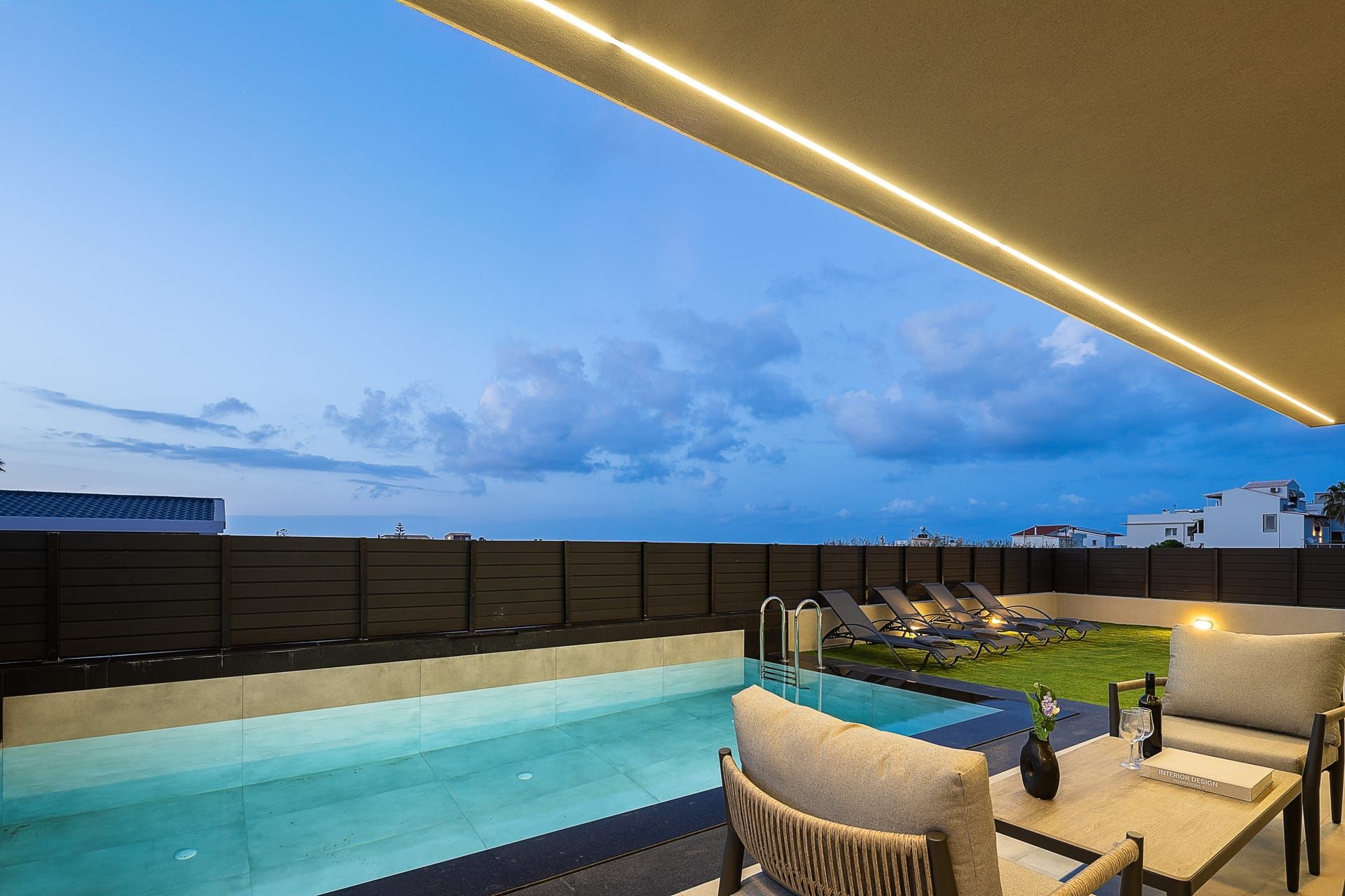 A rooftop pool area with a clear view of the sky and distant buildings.