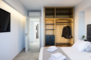 A hotel room with a bed, a wardrobe, a television, and a hallway. - Resmi SeaView Villa, Villa (Kokkini Hani)