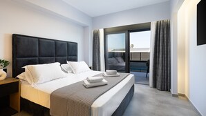 A modern hotel room with a large bed, a bedside table, and a view of the outside.