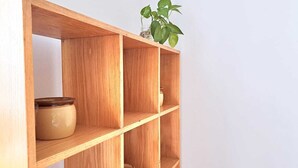 Une étagère en bois à trois niveaux, chaque niveau étant muni d’un pot en céramique.