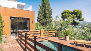 A wooden deck with a pool, outdoor seating, and a view of a cityscape. - Wonderful Villa, swimming pool and parking (Nice)
